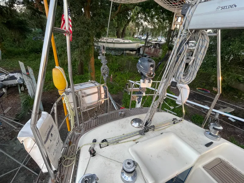 Slide: The Image of 1990 Maxi 35 CC sailboat deck with rigging and equipment, docked near lush greenery. - 29