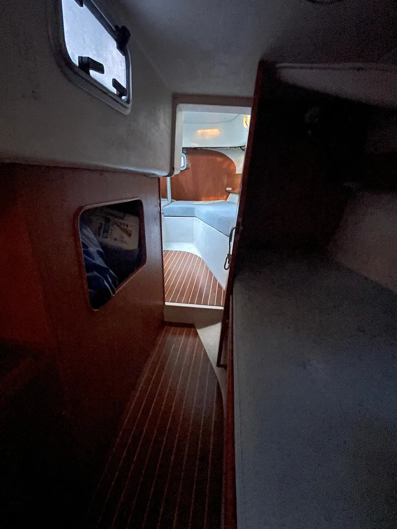 Slide: The Image of Interior of 1990 Maxi 35 CC sailboat, featuring wooden flooring and cozy cabin space. - 35
