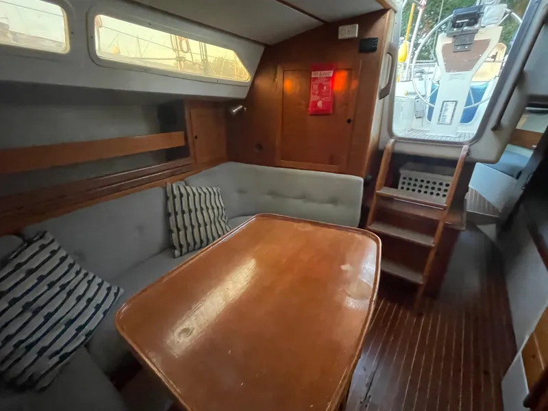 Slide: The Image of Cozy interior of 1990 Maxi 35 CC sailboat with wooden table and cushioned seating. - 40