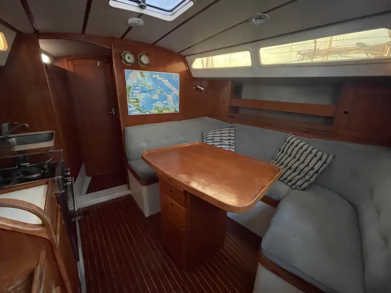 Slide: The Image of Cozy interior of 1990 Maxi 35 CC sailboat with wooden table and seating area. - 43