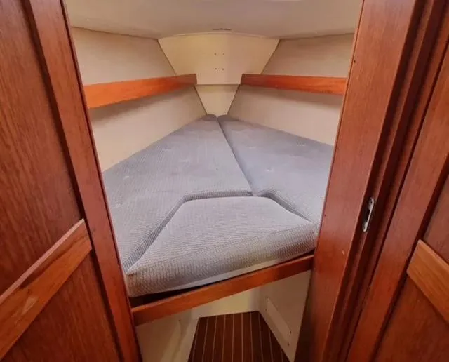 Slide: The Image of Cozy cabin interior of 1990 Maxi 35 CC sailboat with wooden trim and cushioned berth. - 44