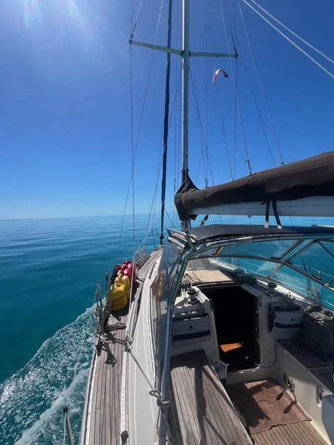 Slide: The Image of Sailing on a 1990 Maxi 35 CC yacht in calm blue waters under a clear sky. - 8