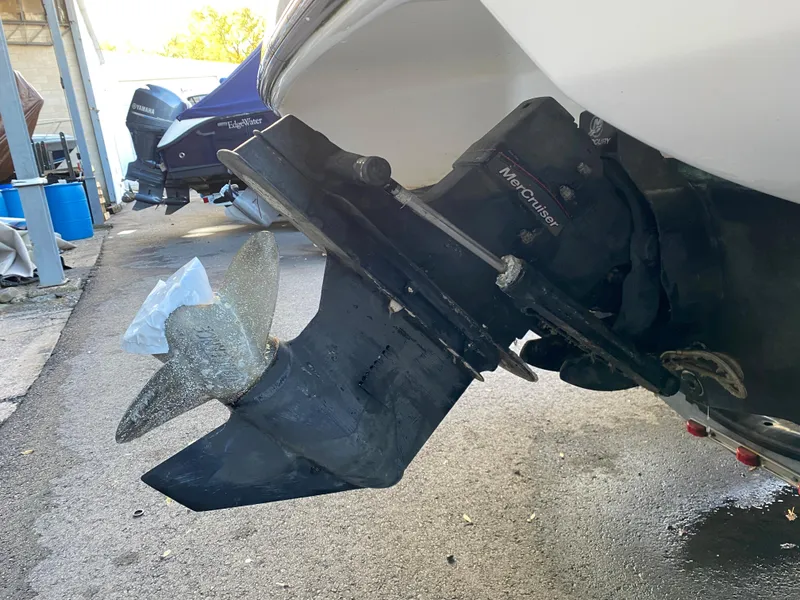 Slide: The Image of 2013 Sea Ray 205 Sport boat with MerCruiser outdrive, parked on pavement. - 11