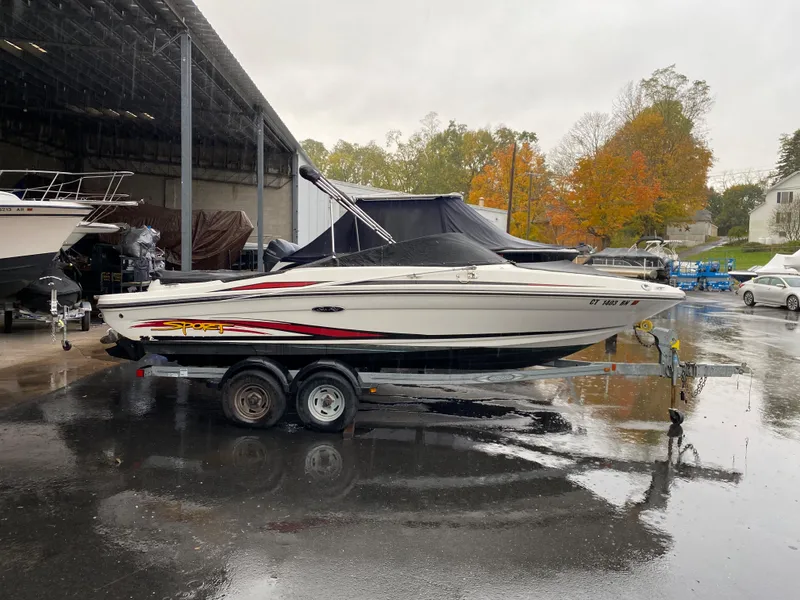 Slide: The Image of 2013 Sea Ray 205 Sport boat on trailer, parked outdoors on a rainy day. - 12