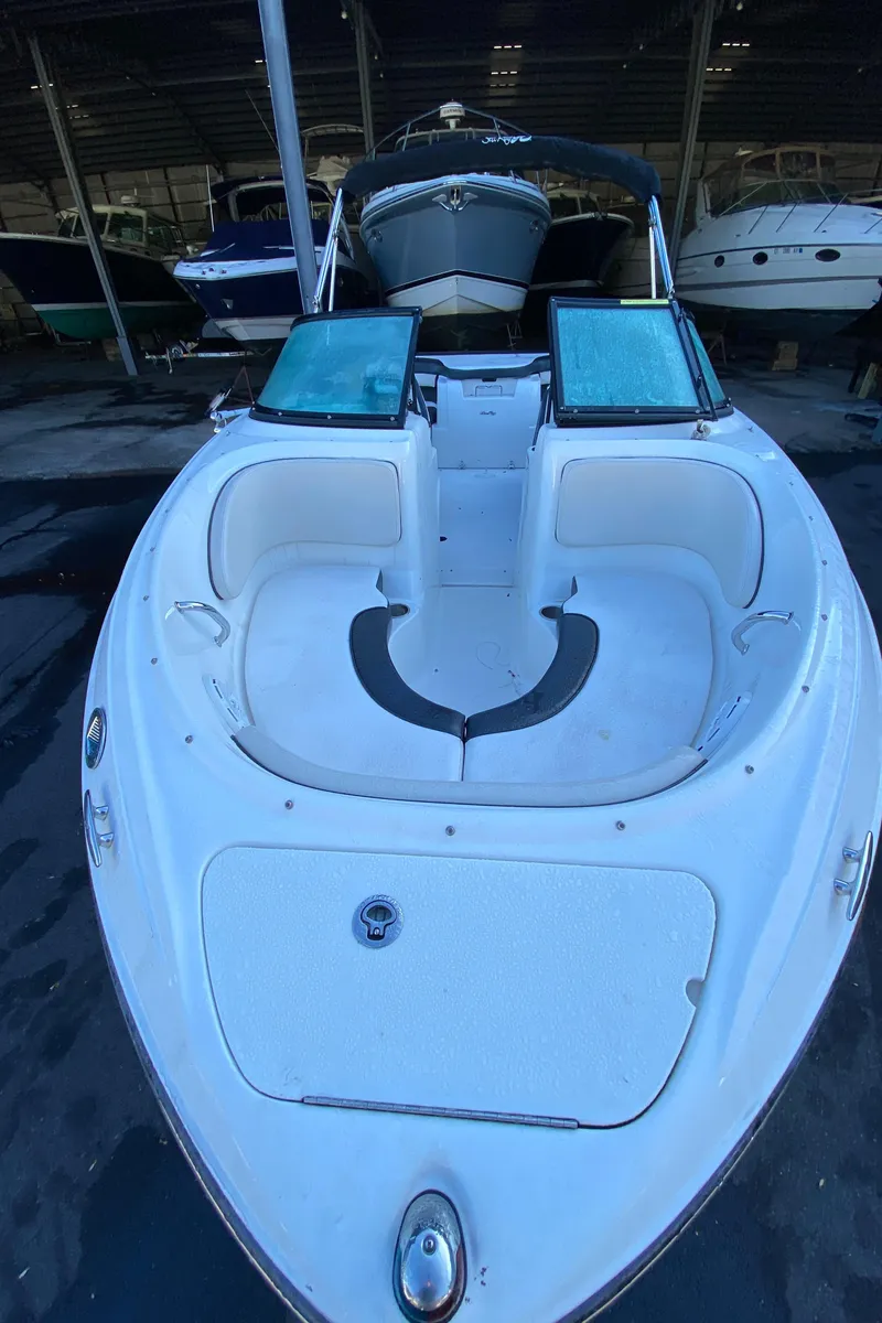 Slide: The Image of 2013 Sea Ray 205 Sport boat with spacious seating, docked in a marina. - 3