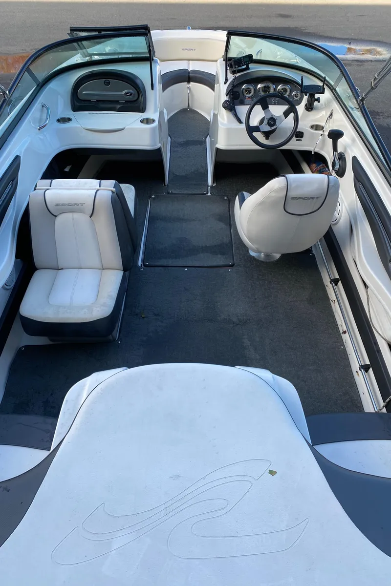 Slide: The Image of 2013 Sea Ray 205 Sport boat interior with white seating and steering console. - 4