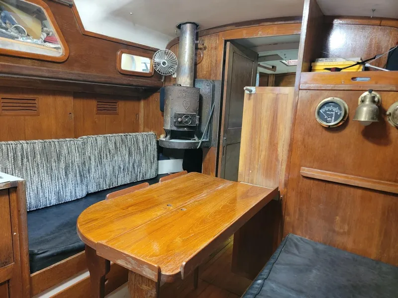 Slide: The Image of Interior of 1968 Cheoy Lee Herreshoff 31 Ketch, featuring wood paneling and cozy seating. - 18