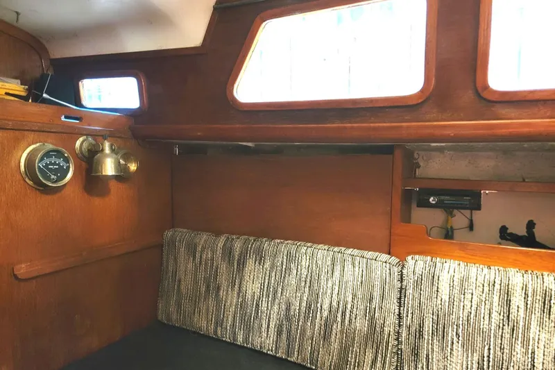 Slide: The Image of 1968 Cheoy Lee Herreshoff 31 Offshore Ketch interior with wood paneling and nautical instruments. - 19