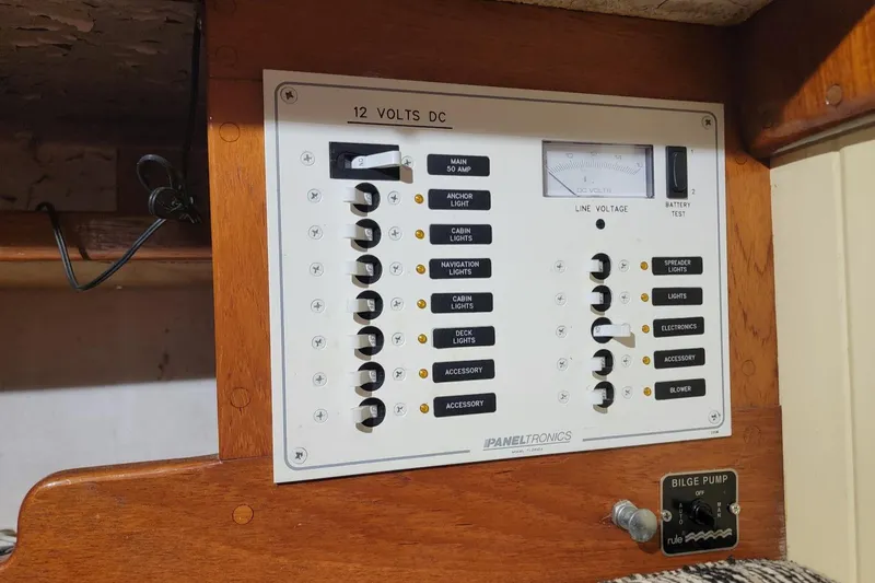 Slide: The Image of Electrical panel on 1968 Cheoy Lee Herreshoff 31 Offshore Ketch, featuring switches and voltage meter. - 21