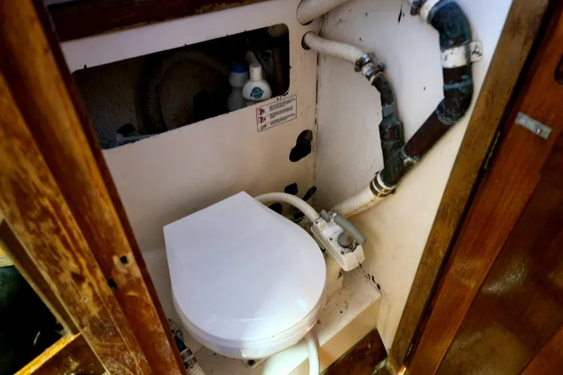 Slide: The Image of 1968 Cheoy Lee Herreshoff 31 Offshore Ketch marine toilet with plumbing and storage. - 22