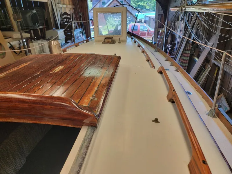 Slide: The Image of 1968 Cheoy Lee Herreshoff 31 Offshore Ketch deck with wooden details in a workshop. - 25