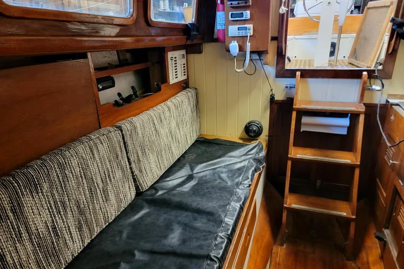Slide: The Image of Interior of 1968 Cheoy Lee Herreshoff 31 Offshore Ketch, featuring wooden furnishings and navigation equipment. - 29