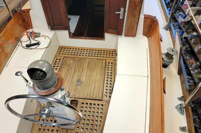 Slide: The Image of 1968 Cheoy Lee Herreshoff 31 Offshore Ketch cockpit with wooden flooring and steering wheel. - 4