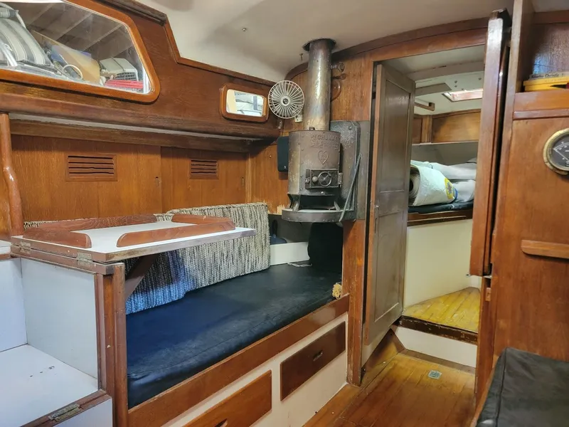 Slide: The Image of 1968 Cheoy Lee Herreshoff 31 Offshore Ketch interior with wood paneling and stove. - 6