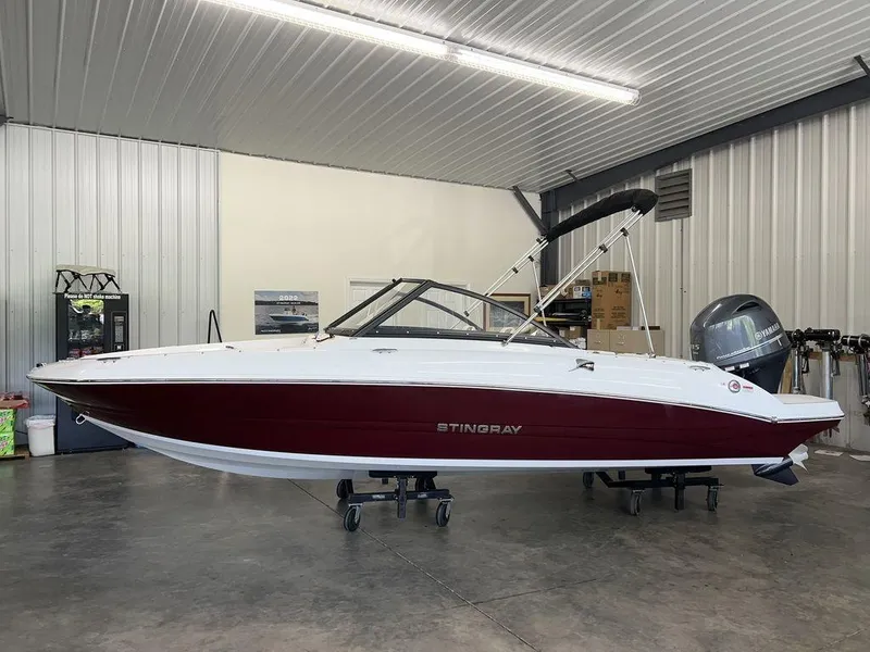 The Image of 2026 Stingray 191 DC boat in a garage, featuring a sleek red and white design. - 0