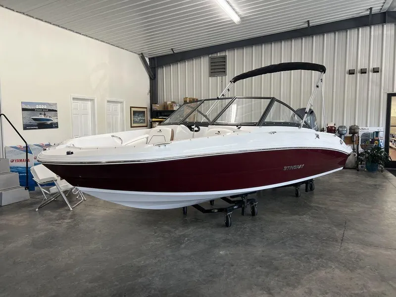 Slide: The Image of 2026 Stingray 191 DC boat in showroom, red and white design, indoor display. - 1