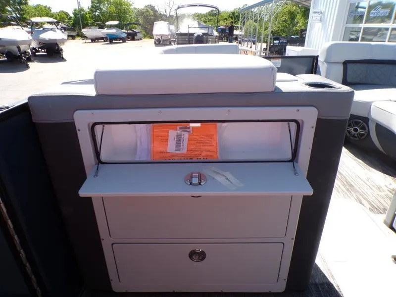 Slide: The Image of 2025 Godfrey AquaPatio 255 SFL iMPACT boat interior with storage compartment open. - 23