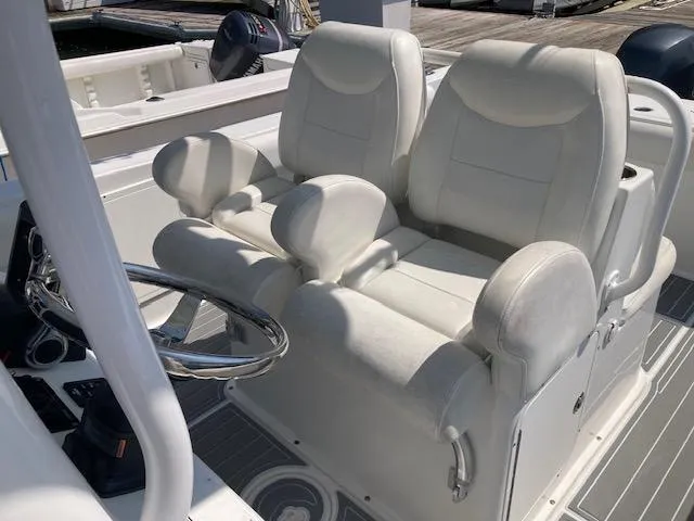 Slide: The Image of 2014 Sea Hunt Gamefish 27 boat with dual white captain's chairs and steering wheel. - 14