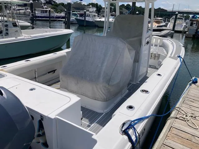 Slide: The Image of 2014 Sea Hunt Gamefish 27 boat docked at marina, covered seats, sunny day. - 7