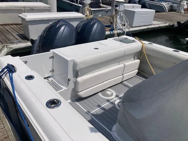 Slide: The Image of 2014 Sea Hunt Gamefish 27 boat docked, featuring dual outboard motors and spacious seating area. - 8