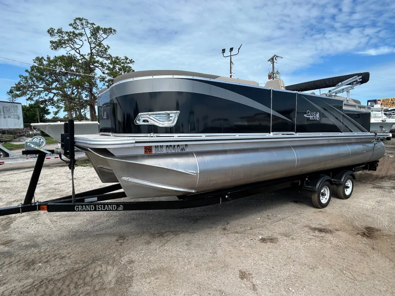 The Image of 2024 Tahoe Pontoon 2385 TZ on trailer, sleek design, parked outdoors. - 1