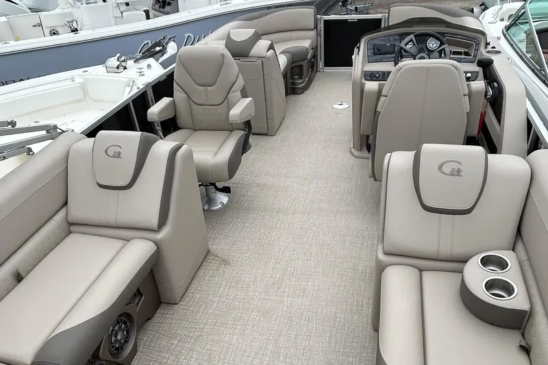 Slide: The Image of 2024 Tahoe Pontoon 2385 TZ interior with luxurious seating and modern dashboard. - 15