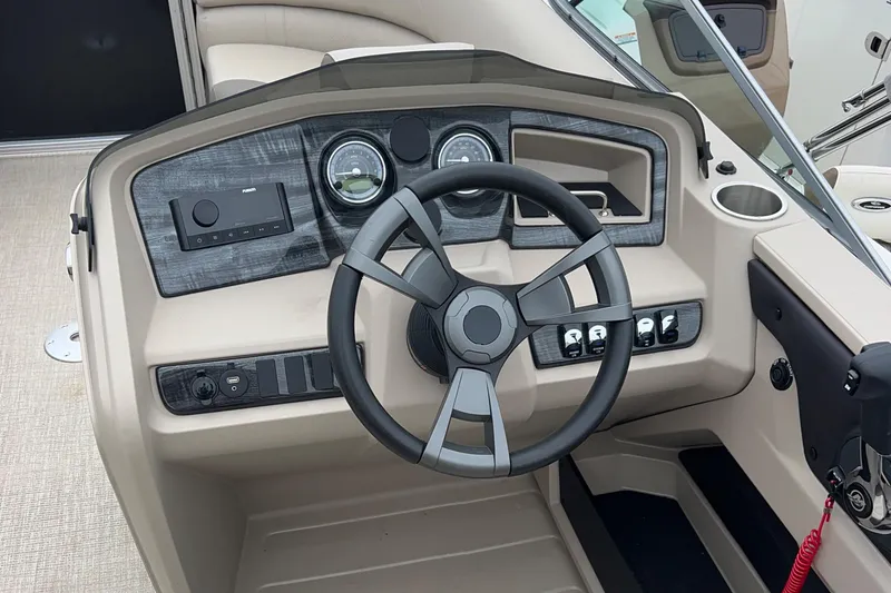 Slide: The Image of 2024 Tahoe Pontoon 2385 TZ dashboard with steering wheel and control panel. - 17