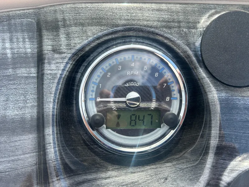 Slide: The Image of 2024 Tahoe Pontoon 2385 TZ RPM gauge displaying 847 RPM on a wooden dashboard. - 21