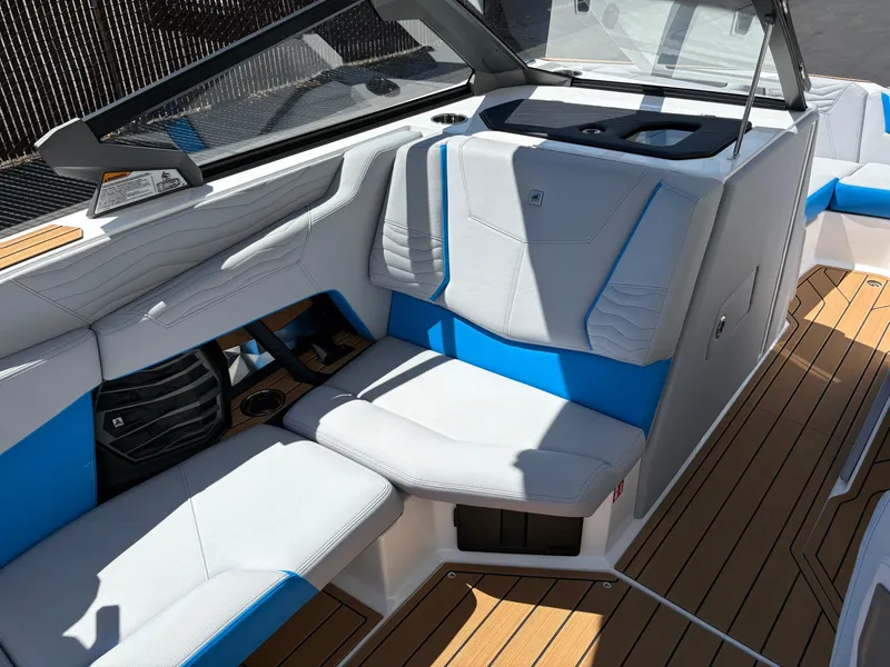 Slide: The Image of 2026 Nautique Super Air Nautique G21 interior with blue and white seating, teak flooring. - 9