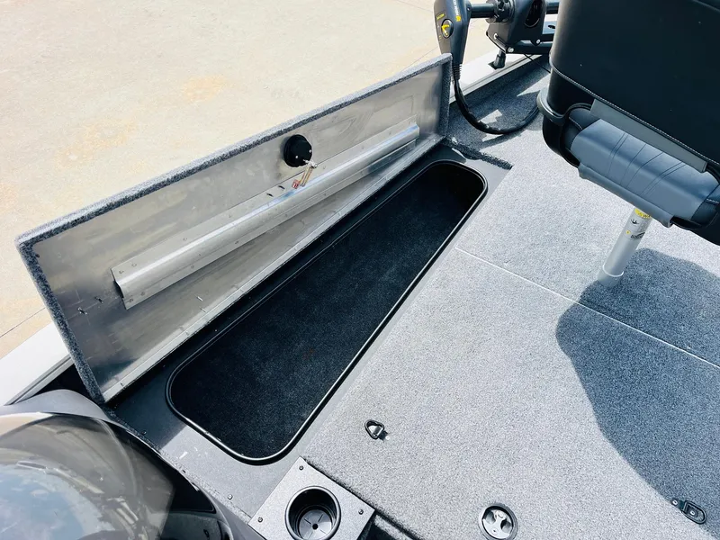 Slide: The Image of 2024 Tracker Pro Team 175 TXW boat storage compartment with open lid and seating area. - 11