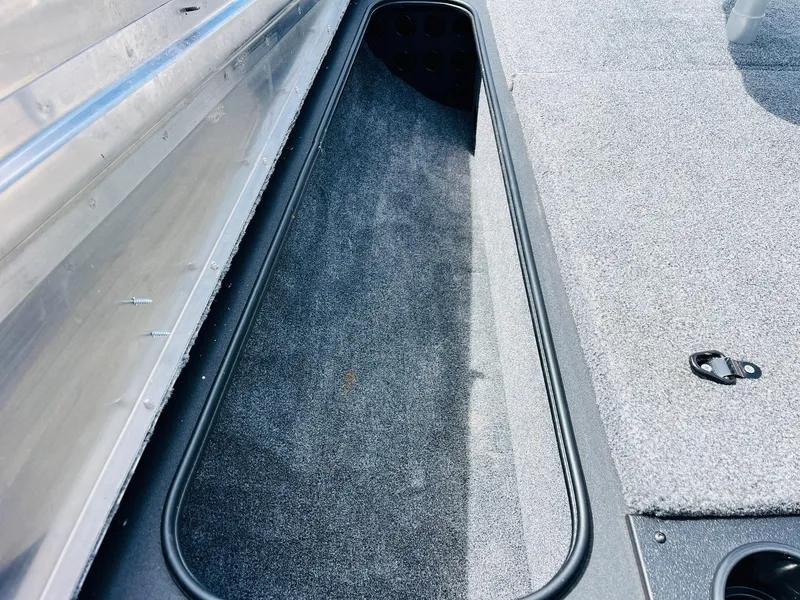 Slide: The Image of 2024 Tracker Pro Team 175 TXW boat storage compartment with carpeted interior. - 12