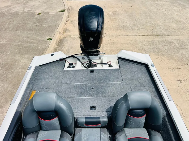 Slide: The Image of 2024 Tracker Pro Team 175 TXW boat interior with gray seats and motor. - 26