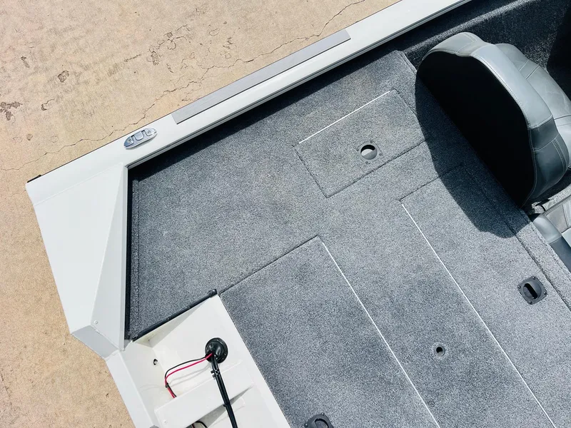 Slide: The Image of 2024 Tracker Pro Team 175 TXW boat interior with gray carpet and seating. - 28