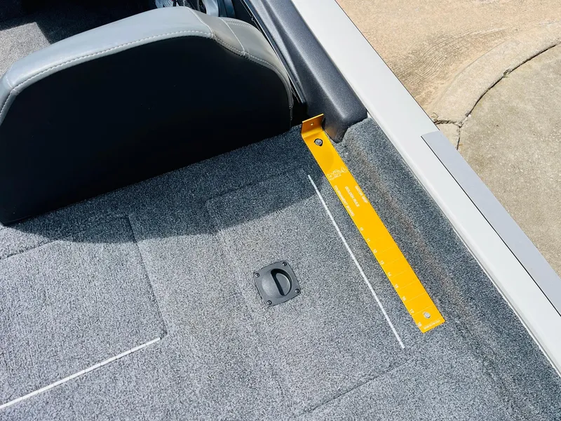 Slide: The Image of 2024 Tracker Pro Team 175 TXW boat interior with measuring ruler and carpeted floor. - 32