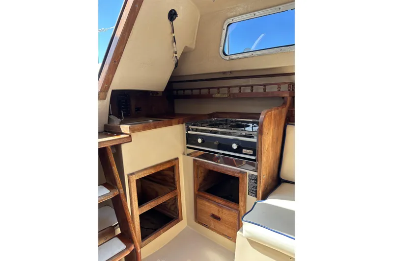 Slide: The Image of Interior of a 1983 Catalina 25 sailboat featuring a compact kitchen area. - 12
