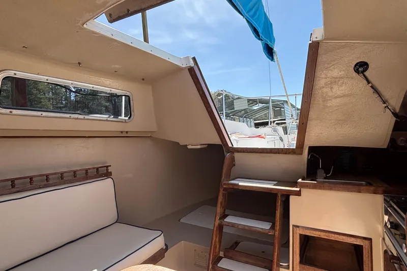Slide: The Image of Interior of a 1983 Catalina 25 sailboat with wooden ladder and seating. - 13