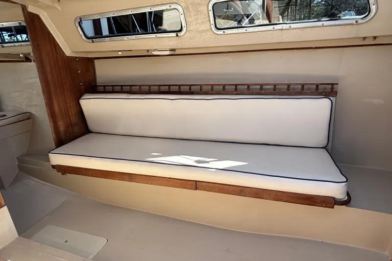 Slide: The Image of Interior of 1983 Catalina 25 sailboat with cushioned seating and wooden accents. - 16