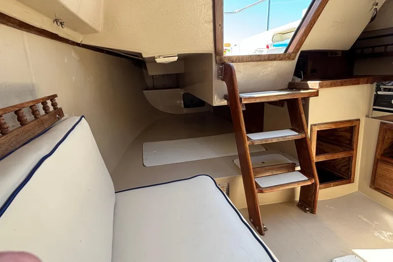 Slide: The Image of Interior of a 1983 Catalina 25 sailboat with wooden steps and cushioned seating. - 22