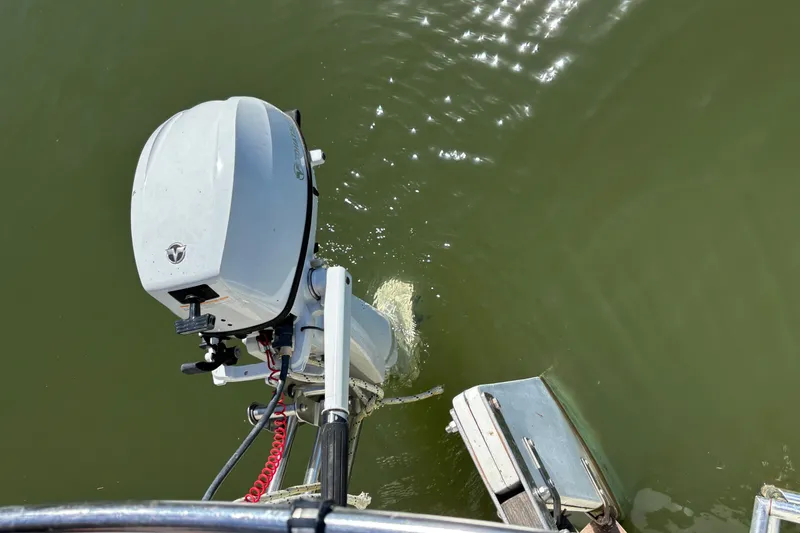 Slide: The Image of Outboard motor on a 1983 Catalina 25 sailboat in calm water. - 27