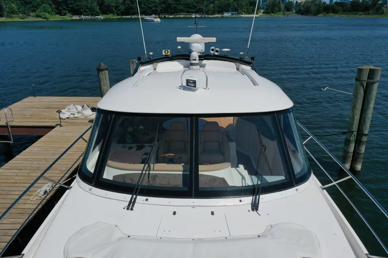 Slide: The Image of 2007 Neptunus 55 Cabrio yacht docked by a serene lake. - 11