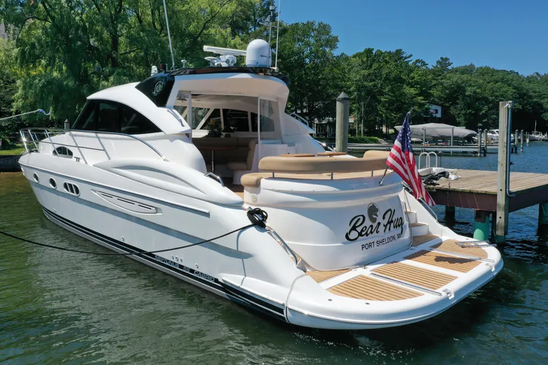 Slide: The Image of Luxury 2007 Neptunus 55 Cabrio yacht docked, featuring sleek design and American flag. - 6