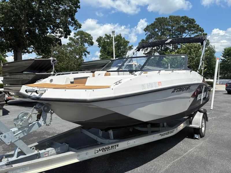 Slide: The Image of 2023 Starcraft SVX 190 OB DC boat on trailer, parked outdoors under a clear sky. - 11