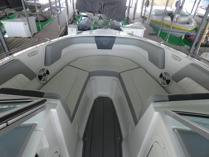 Slide: The Image of 2020 Chaparral 23 SSi boat interior with gray seating and speakers in a dock setting. - 17