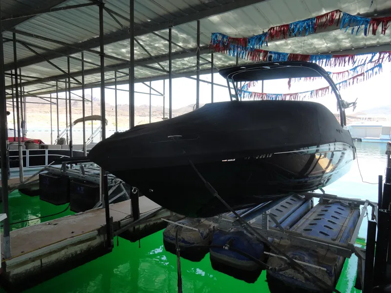 Slide: The Image of 2020 Chaparral 23 SSi boat docked in a covered marina with festive decorations. - 22