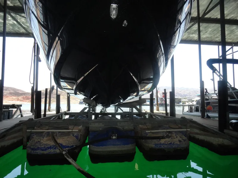 Slide: The Image of 2020 Chaparral 23 SSi boat in dock, viewed from below, with green water reflection. - 23