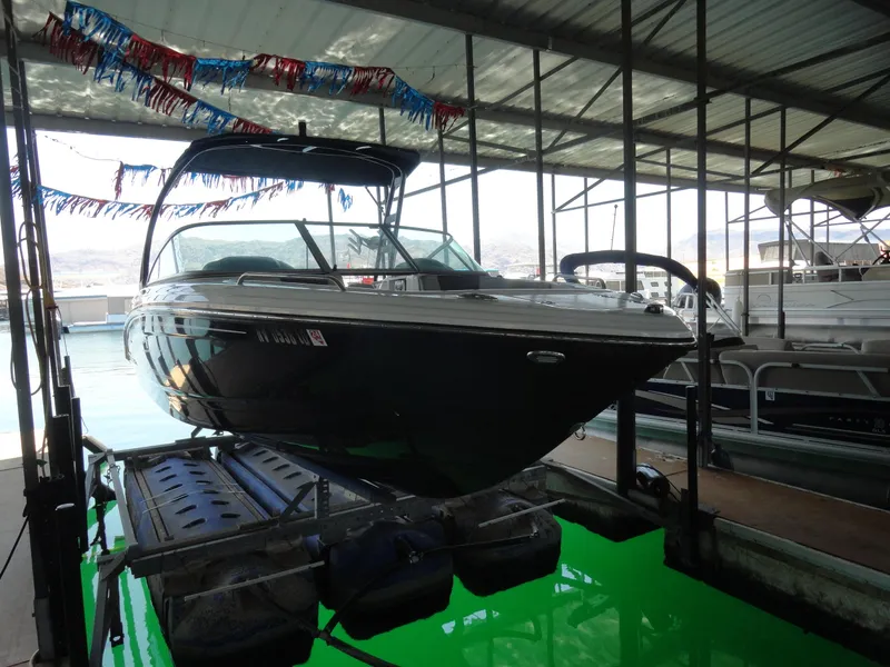 Slide: The Image of 2020 Chaparral 23 SSi boat docked in a covered marina with festive decorations. - 3
