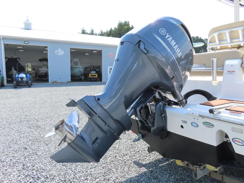 Slide: The Image of 2018 Sea Fox 226 Commander with Yamaha outboard motor, parked on gravel near a boat garage. - 5