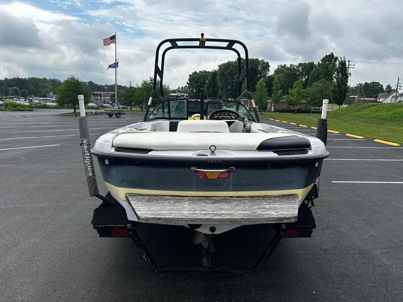 Slide: The Image of 2000 Correct Craft Air Nautique boat on trailer in parking lot, flags in background. - 3