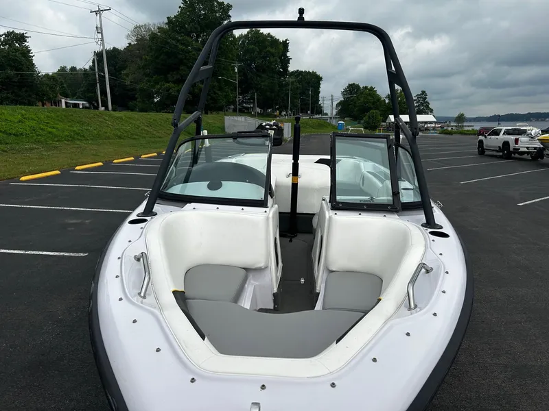 Slide: The Image of 2000 Correct Craft Air Nautique boat in parking lot, featuring open bow seating and wakeboard tower. - 4