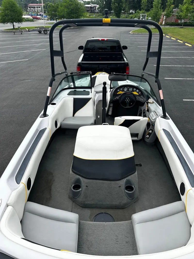 Slide: The Image of 2000 Correct Craft Air Nautique boat interior with seating and dashboard, parked in a lot. - 6